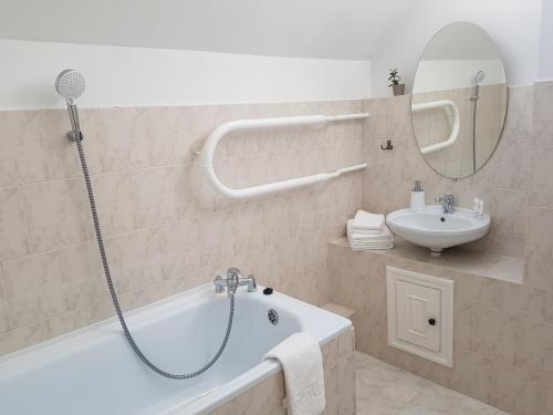 a bathroom with a bath tub and a sink at Hotel Melturi in Melturi