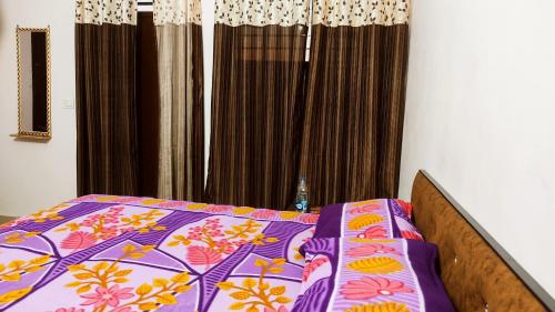 1 dormitorio con 1 cama con un edredón colorido en NOOR Inn & Guest House -Couples Favorite,Local ID Accepted -- High Rated by Couples en Jalandhar