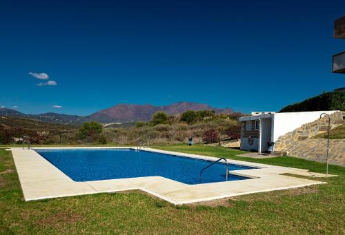 ein Schwimmbad in einem Hof neben einem Haus in der Unterkunft Hacienda Dona JULIA GOLF Estepona in Casares