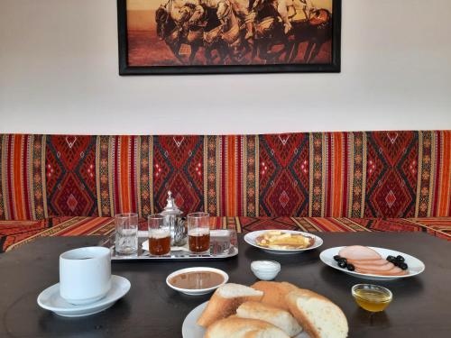 einen Tisch mit Teller mit Essen und Brot darauf in der Unterkunft DARKOM in Ad-Dakhla