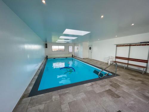 a large indoor swimming pool in a building at TY MENEZ HEOL - Magnifique villa avec piscine in Ploudalmézeau