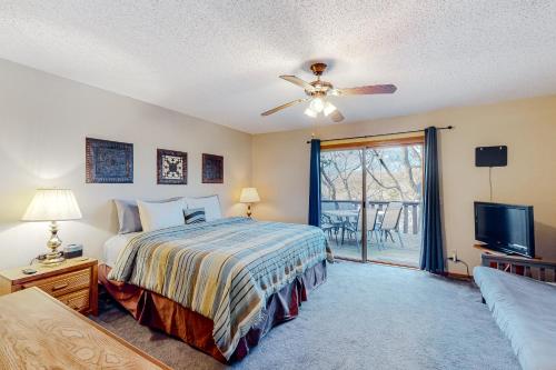 a bedroom with a bed with a ceiling fan and a tv at Holiday Island Overlook in Eureka Springs
