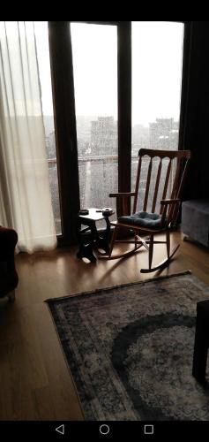 a rocking chair in a room with a large window at Private Room in Istanbul #44 in Tuzla