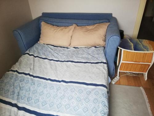 a bed with a blue and white comforter at Private Room in Istanbul #44 in Tuzla