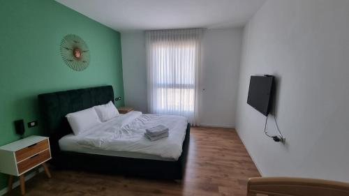 una camera da letto con un letto e una televisione di Apartment Sandarella a Bat Yam