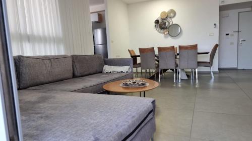un soggiorno con un divano, un tavolo e delle sedie di Apartment Sandarella a Bat Yam