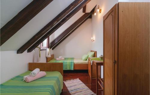 a attic room with two beds and a staircase at Nice Home In Nerezisca With 3 Bedrooms, Wifi And Outdoor Swimming Pool in Nerežišće