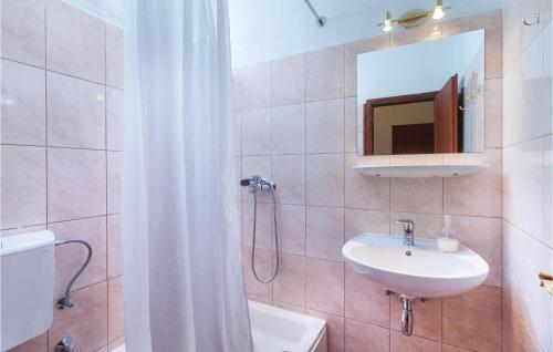 a bathroom with a sink and a toilet and a mirror at Nice Home In Nerezisca With 3 Bedrooms, Wifi And Outdoor Swimming Pool in Nerežišće