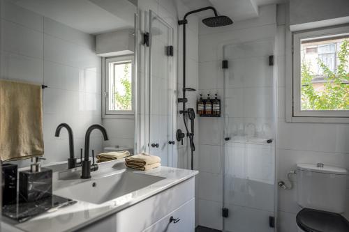 a white bathroom with a sink and a shower at Unique & Upscale Gem in Tel Aviv