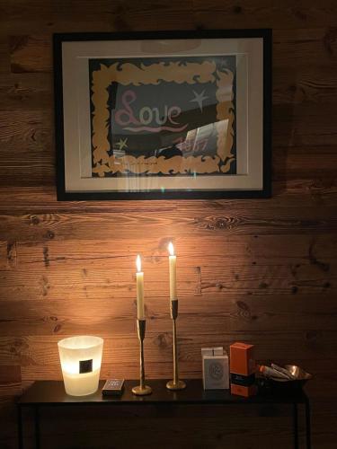 two candles sitting on top of a table with a picture at Standing Megeve - 2 to 8 people - Mont d'Arbois in Megève
