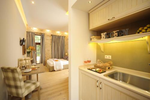 eine Küche mit einem Waschbecken und ein Zimmer mit einem Bett in der Unterkunft Pepi Boutique Hotel (Adults Only) in Rethymno
