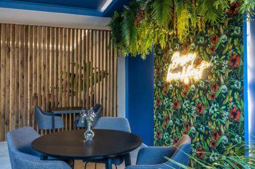 a table and chairs in a restaurant with a wall of flowers at Bossa & Bed Hostel in Lisbon