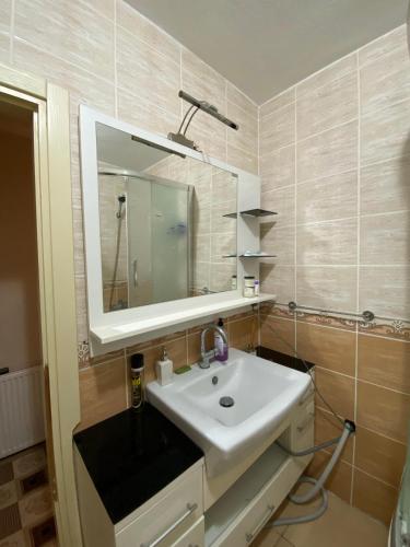 ein Badezimmer mit einem weißen Waschbecken und einem Spiegel in der Unterkunft Private Room in Istanbul #46 in Pendik