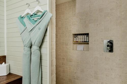 - une serviette accrochée au mur dans la salle de bains dans l'établissement Soho Beach House Canouan, à Canouan