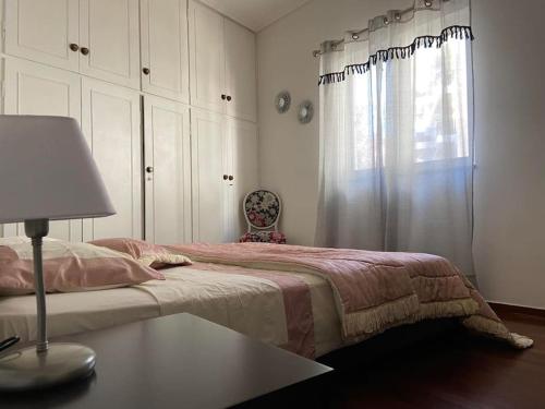 een slaapkamer met een bed met een tafel en een raam bij Irene's Guest Home in Chalkida
