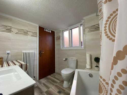 een badkamer met een toilet, een wastafel en een bad bij Irene's Guest Home in Chalkida