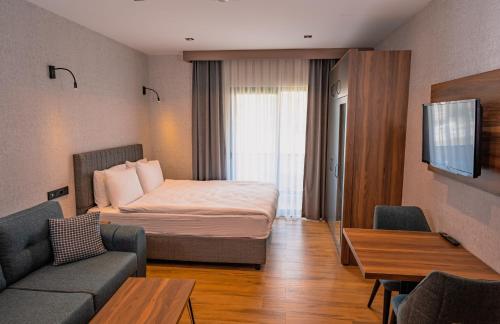 ブルサにあるGörükle Alpaş Yaşam Hotelのベッドとソファ付きのホテルルーム