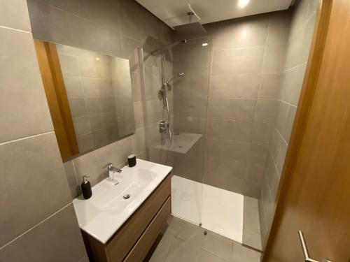 La salle de bains blanche est pourvue d'un lavabo et d'une douche. dans l'établissement La casa, à Casablanca