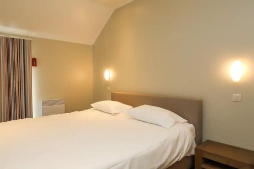 una camera da letto con un grande letto bianco con due cuscini di Villa 2 chambres au bord du lac de l'Eau d'Heure a Froidchapelle