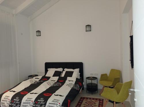 een slaapkamer met een bed en een groene stoel bij צימר ברחובות- Tara ארוח Tzimmer יש ממד במתחם in Rechovot