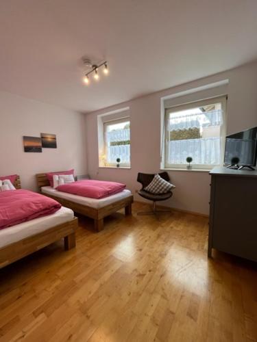 a room with two beds and a tv and two windows at Allgäutraum Ferienwohnung Nr 4 in Kempten