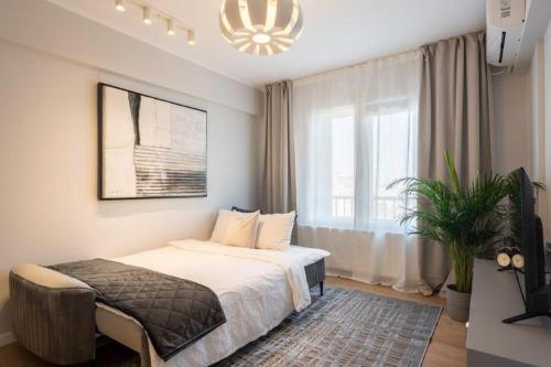 1 dormitorio con cama y ventana grande en Downtown Modern - 2BR Apartment, en Bucarest