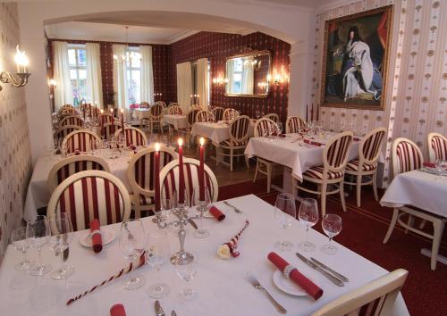 un comedor con mesas y sillas blancas en Hotel Posthof, en Sankt Wendel