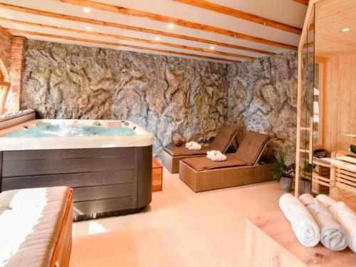 a large bathroom with a tub and a bed and a tub at Spa Oasis Samanta in Ludbreg