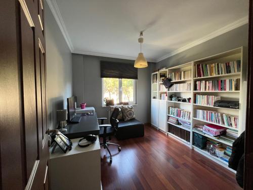 una oficina con escritorio, ordenador y estanterías de libros en Private Room in Istanbul #48, en Tuzla