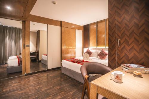a hotel room with a bed and a desk and a table at Amritara Kirpa, Amritsar in Amritsar