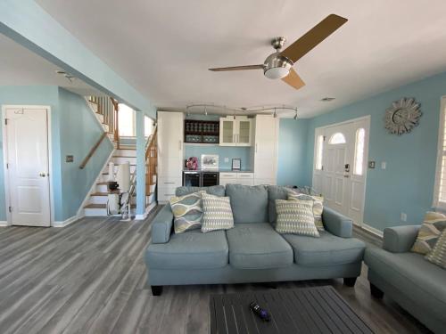 a living room with a blue couch and a ceiling fan at 3 bedroom Atlantic City House Steps from Boardwalk, beach, shopping , nightlife. in Atlantic City