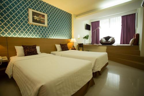 a hotel room with two beds and a window at P2 Boutique in Bangkok