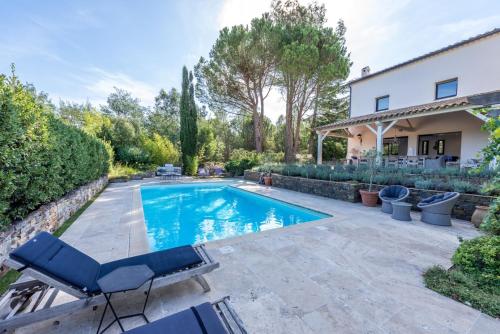 une piscine dans l'arrière-cour d'une maison dans l'établissement Villa Le Bastidou, au Plan-de-la-Tour