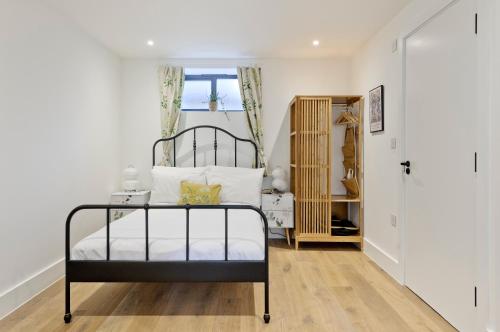 ein Schlafzimmer mit einem schwarz-weißen Bett in einem Zimmer in der Unterkunft Luxury one bedroom Greenwich studio apartment near Canary Wharf by UnderTheDoormat in London
