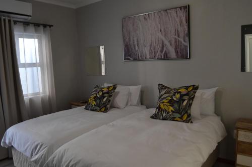 a bedroom with two beds with pillows on them at Quiver Inn Guesthouse in Keetmanshoop