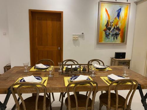 a dining room table with chairs and a painting on the wall at Luxury Penthouse, Nilaveli in Trincomalee