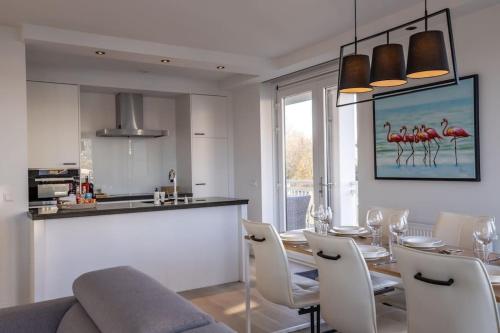 een keuken en een eetkamer met een tafel en stoelen bij Home Away, Light and Bright in Cadzand