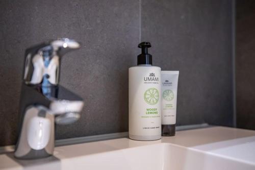 a bottle of sunscreen sitting on top of a bathroom sink at Home Away, Light and Bright in Cadzand