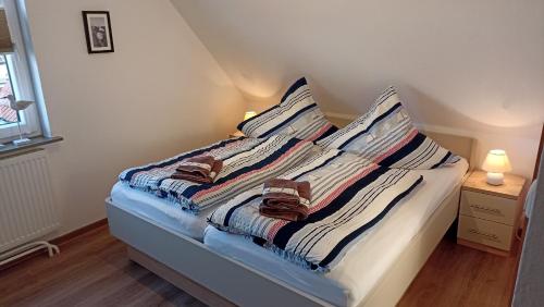 ein Bett mit zwei Handtüchern auf einem Zimmer in der Unterkunft Haus Anker in Neuharlingersiel