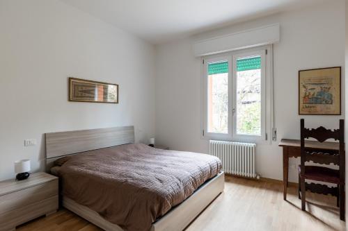 a bedroom with a bed and a desk and a window at Casa con giardino a Borgo Panigale in Bologna