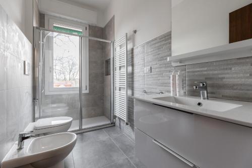 een witte badkamer met een wastafel en een toilet bij Casa con giardino a Borgo Panigale in Bologna