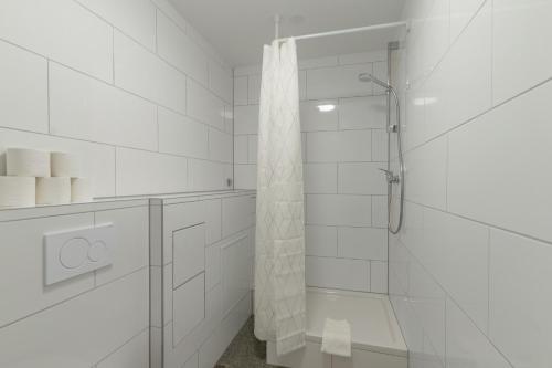 a white bathroom with a shower with a glass door at T&K Apartments - 3 - 5 Group Room Apartments- 15min to Fair DUS in Neuss