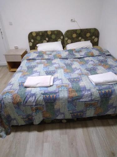 a bed with a colorful quilt and pillows on it at VILLA SIMKA in Kočani