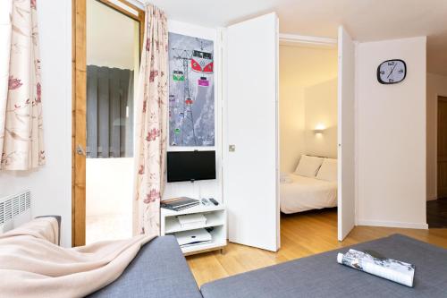 Habitación pequeña con cama y TV. en Apartment Chamois Blanc 2, en Chamonix-Mont-Blanc