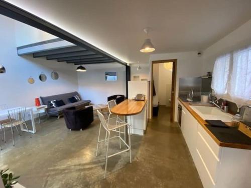 a kitchen and living room with a counter and a table at Maison duplex avec terrasse proche de la gare SNCF in Clermont-Ferrand