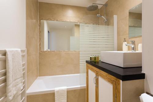 une salle de bain avec une baignoire, un lavabo et une douche dans l'établissement Apartment Chamois Blanc 2 Centre Chamonix Mont Blanc, à Chamonix-Mont-Blanc