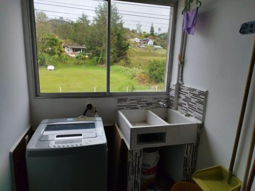 a kitchen with a sink and a window at APARTAMENTO BALCON DE LA ESPERANZA GUATAPE in Guatapé