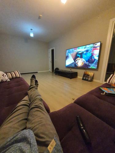 a person laying on a couch watching a tv in a living room at Private Room in Istanbul #50 in Tuzla