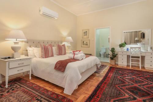 a bedroom with a white bed and a rug at Elgin Country Lodge in Elgin