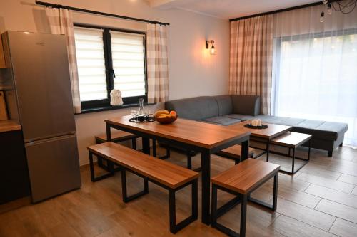 a living room with a table and a couch at Willa i domki Victoria in Wisła